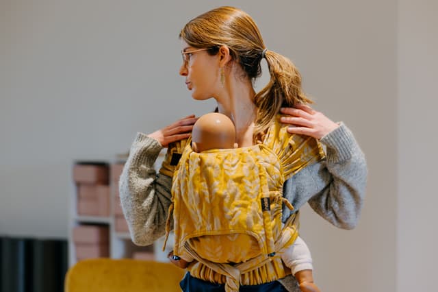 Femme avec bébé en Portage physiologique
